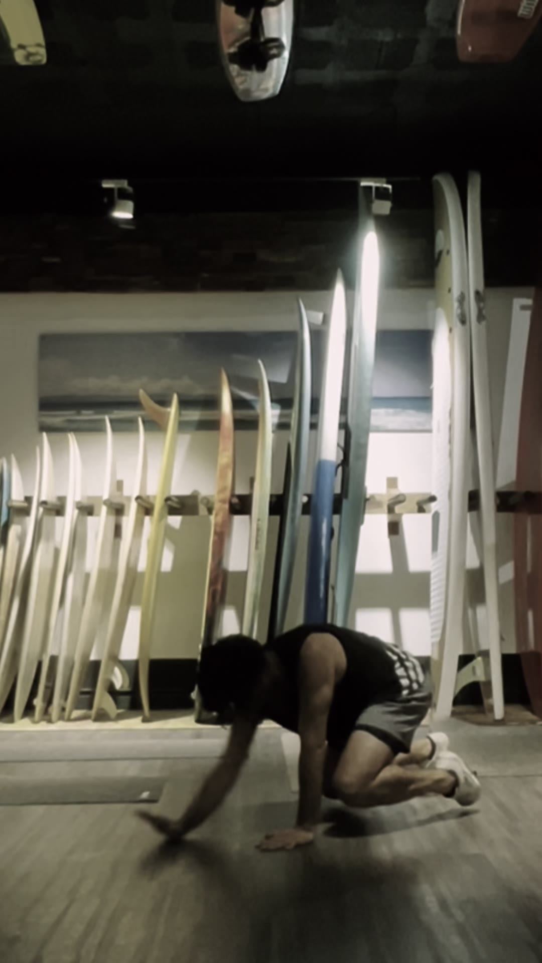 Beast reach in a studio with a rack of surfboards behind
