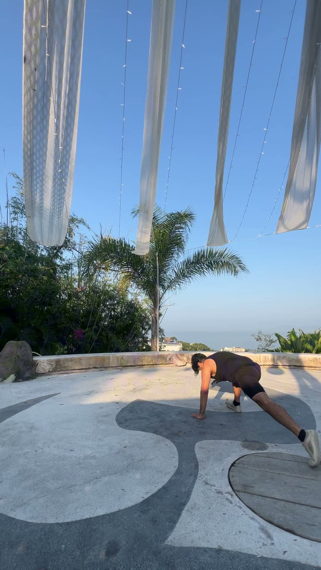 Flow practice on a terrace with sails and palms